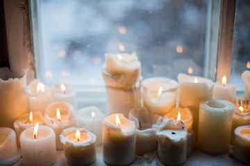 burning candles on windowsill