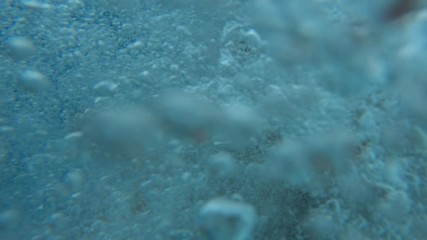 Handsome young man jumping from a boat or yacht into the sea or ocean. Summer vacation with friends. Tourists have fun and dive. Slow motion.