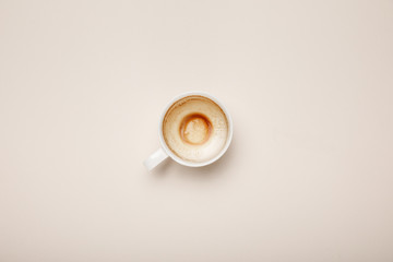 top view of coffee cup with foam on beige background