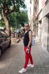 Sportive homosexual man with makeup posing with passion on street