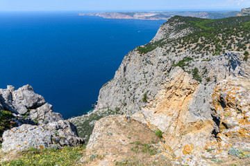 Fototapeta na wymiar view of the Black Sea from the height of Mount Ayia, a cape on the southern coast of the Crimea, to the south-east of Balaclava. Sunny bright day with clouds on the sky. Spring view of the Crimea.