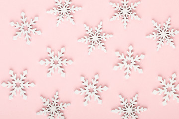 Christmas background. White snow decorations on a pink background.