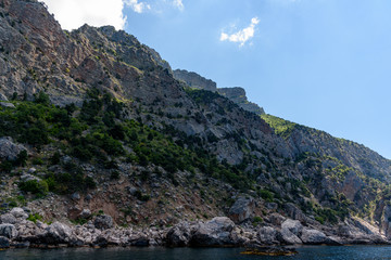 Fototapeta na wymiar cliff shore from the side of a pleasure boat in the black sea, on a sunny day with clouds in the sky.