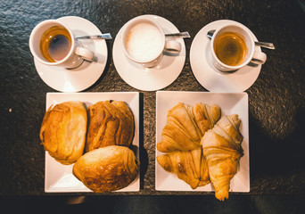 Top view of continental breakfast concept. Fresh coffee with croissants in cafe.