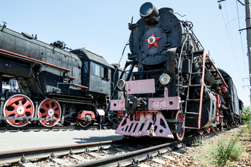 Fototapeta na wymiar Black Soviet locomotive with a red star is on the rails.