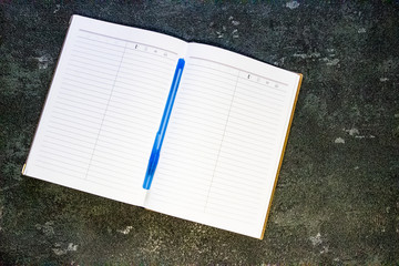 Pen and pencil lie on a notebook, view from the top. Self-adhesive paper for notation. Scissors and...