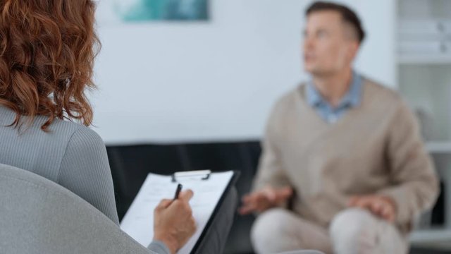 selective focus of psychologist listening to patient 