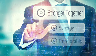 Fototapeta na wymiar A businessman selecting a Stronger Together button on a futuristic display with a concept written on it.