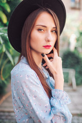 Lifestyle portrait of beautiful brunette woman in elegant hat