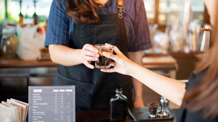 Close up of female hand is taking hot coffee from Barista