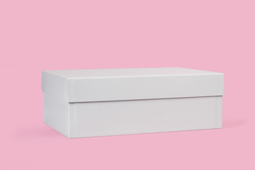 Caja de cartón blanca sobre un fondo rosa aislado. Vista de frente. Copy space