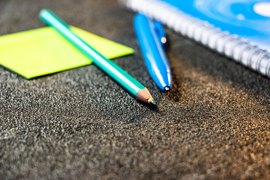 A Blue Notebook Stunned With Self-adhesive, A Pen And A Pencil Lying Next To It. View From Above. On A Black Background.