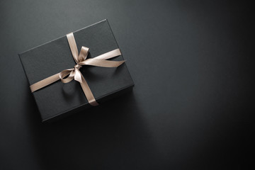 Gift wrapped in dark paper on dark background