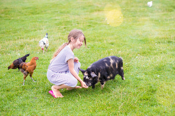 pretty little girl taking care of a dwarf pig