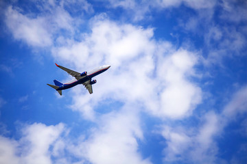 Fototapeta na wymiar Passenger commercial plane in flight. The aircraft flies airplane a background of clouds. Aircraft side view. - Image