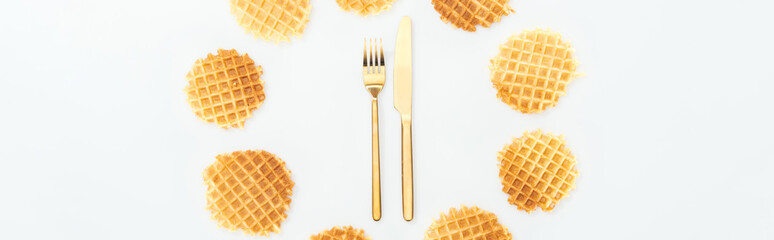 panoramic shot of waffle in circle with cutlery in middle isolated on white