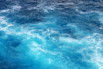 Shot of sea of ocean surface with moving water making foam .