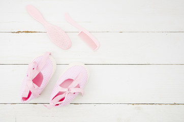 Top view baby shoes with wooden background