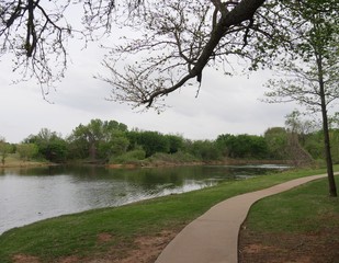 Nature view of a lake with a concrete walkway for joggers