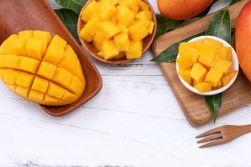 Fresh chopped mango on a tray and bright rustic wooden background. Tropical summer fruit design...