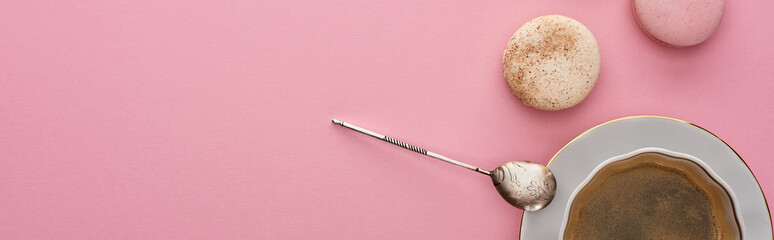 top view of delicious French macaroons near coffee on pink background with copy space, panoramic shot