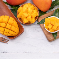 Fresh chopped mango on a tray and bright rustic wooden background. Tropical summer fruit design...