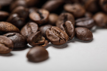 close up view of delicious fresh textured coffee grains on white surface