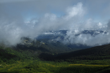 clouds soar over a beautiful view of a mountain range