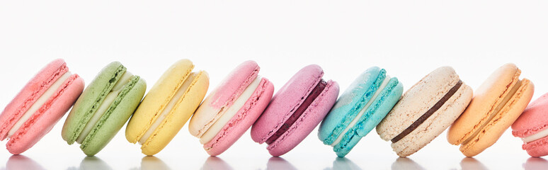 row of delicious colorful French macaroons of different flavors on white background, panoramic shot