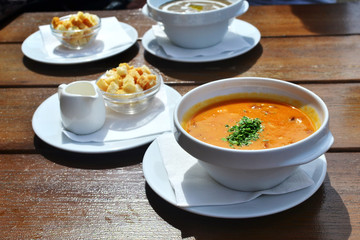 pea soup with smoked meats on a table in a cafe, in a white plate, top view