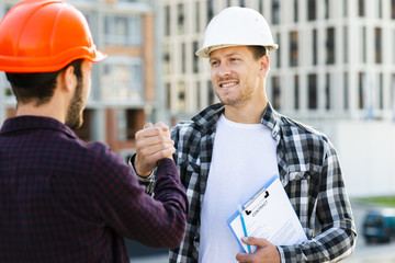 Close-up of engineer and architect  shaking hands