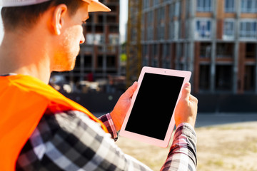 Close-up side view construction engineer using tablet