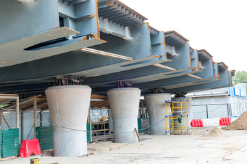 Bridge from steel with concrete columns and road under construction 