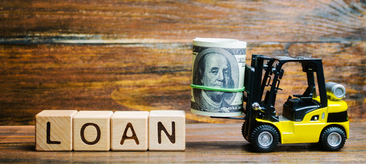 Wooden blocks with the word Loan and forklift. Credit provided by the lender to the borrower at a...