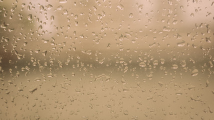 Rain Drops On Surface of wet Window Glass pane In Rainy Season. Abstract background. Natural Pattern of raindrops isolated from outdoor cloudy environment.
