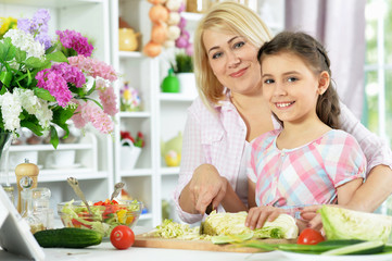 Cute little girl with her mother cooking together