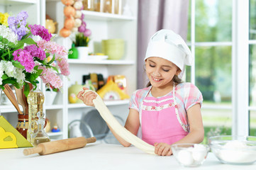Cute girl making dough in the kitchen
