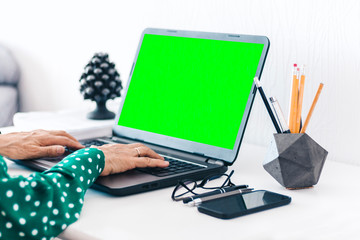 hands  woman typing on keyboard green screen laptop, concrete holder with pencils and pens,...