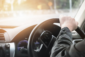 Driver hand hold steering wheel to control and turn right on sharp curve road.