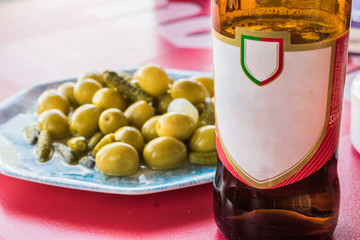 beer bottle with plate of olives