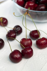 cherries in a bowl isolated on white. fresh red cherries on a white table.