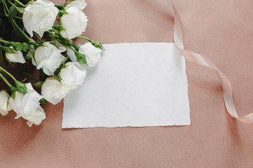 Fototapeta premium White roses background. Elegant flat lay with flowers and ribbon