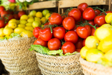 red tomatoes on branch in wicker baskets on counter