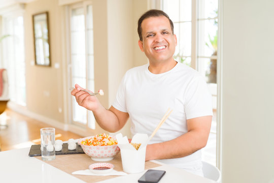 Middle age man eating asian food at home
