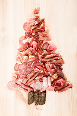 Christmas tree made of sausage on a background of a wooden wall