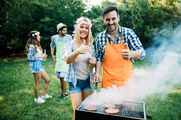 Group of friends having fun in nature doing bbq