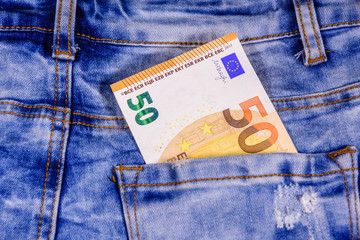 Fifty euro banknote in pocket of the blue jeans