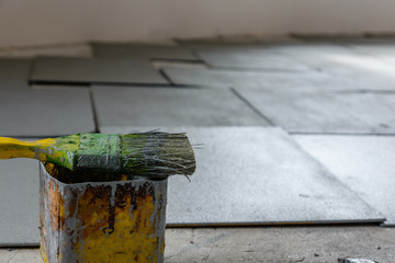 Dirty green paintbrush on a chipboard. House renovation