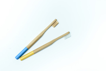 blue and yellow bamboo toothbrushes on white  background. Place for text. Ecoproduct. eco-friendly