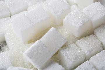 Closeup of granulated and sugar cube on black background